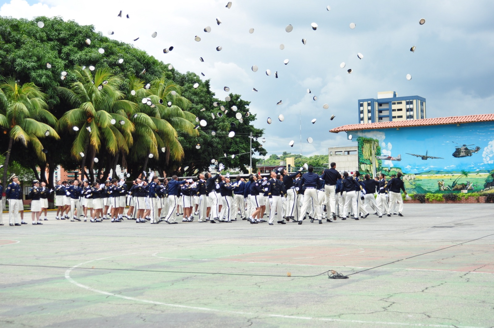 Cadetes de la promoción saliente lanzando sus quepis al cielo durante el acto de ósculo de bandera
